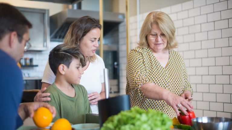 Three generations preparing a meal together in a modern kitchen, fostering family bonds and culinary skills.